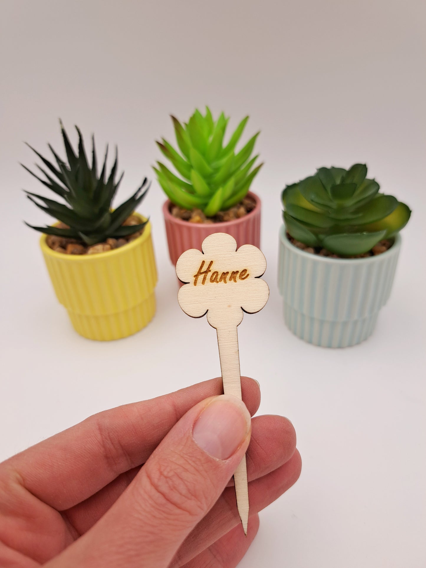 Houten prikker met naam bloem in hand